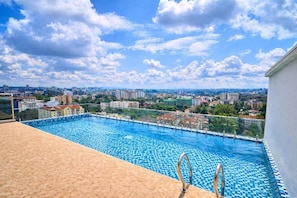 A rooftop infinity pool with a city view, surrounded by buildings. - Marina Bay Deluxe 2BR (Nairobi)