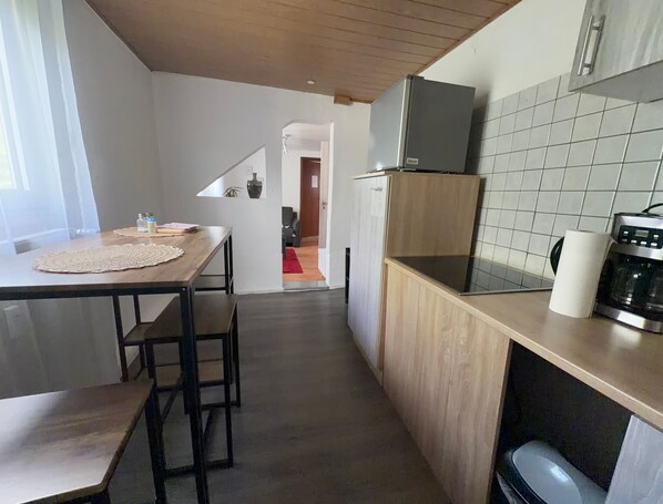 Eine moderne Küche mit einer Holz Arbeitsplatte, einem eingebauten Ofen und einem Kühlschrank.