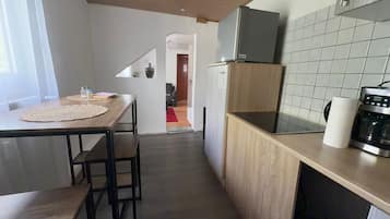 Una cocina moderna con encimera de madera, horno integrado y refrigerador.