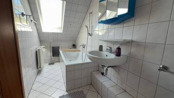 Ein modernes Badezimmer mit Badewanne, Waschbecken und Dusche.