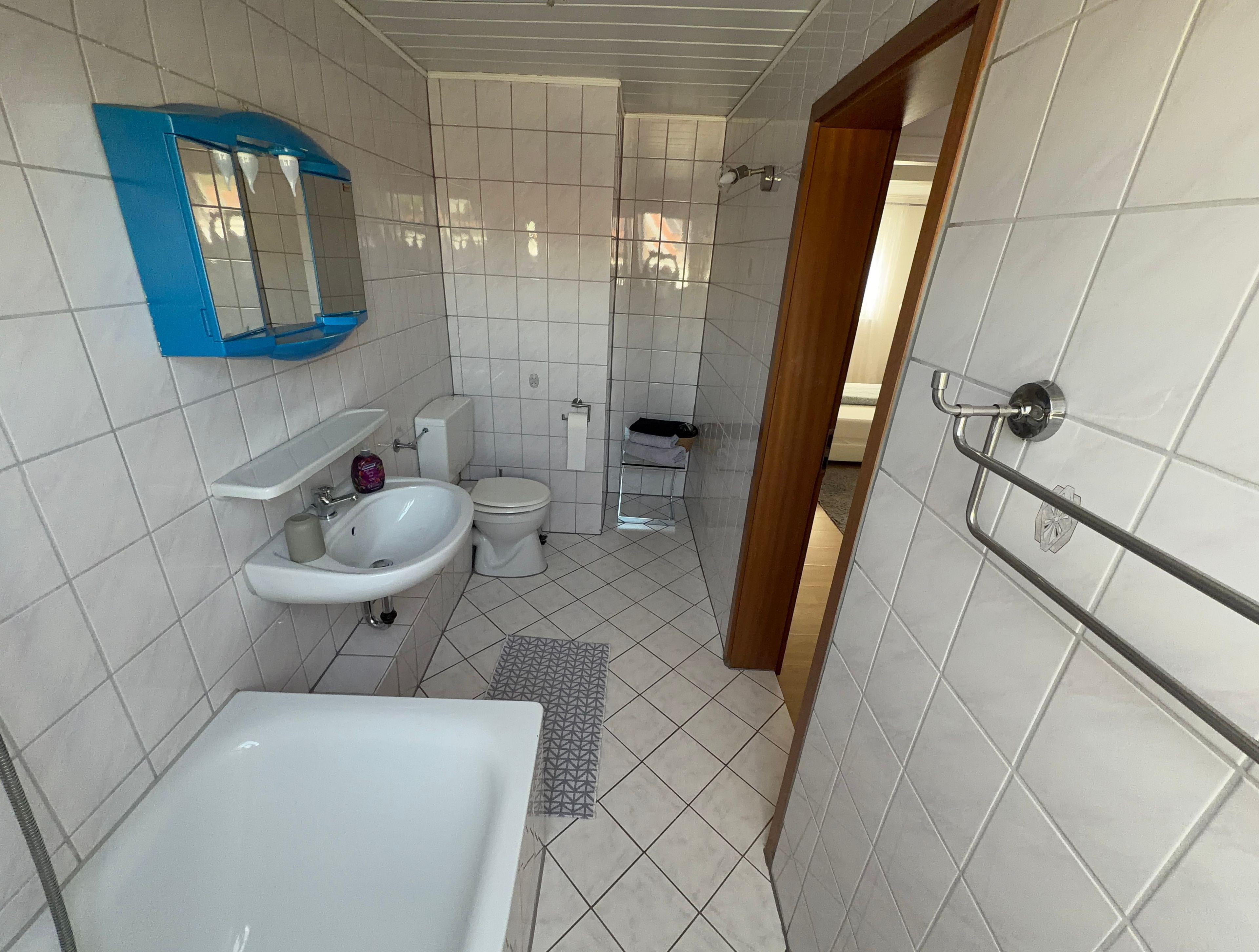 A bathroom with a bathtub, sink, toilet, and a mirror.