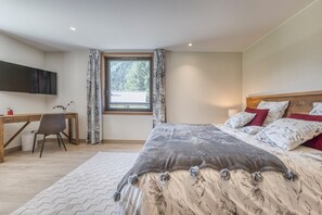 Ein Schlafzimmer mit Bett, Schreibtisch und Fenster.