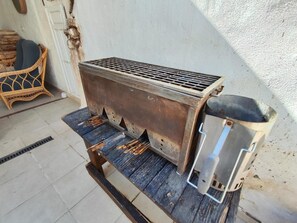 A portable grill with a metal grate and a metal container, placed on a wooden platform. - Holiday Home 'Casa Rural Spa Exterior' with Mountain View, Wi-Fi and Air Conditioning (Cacín)