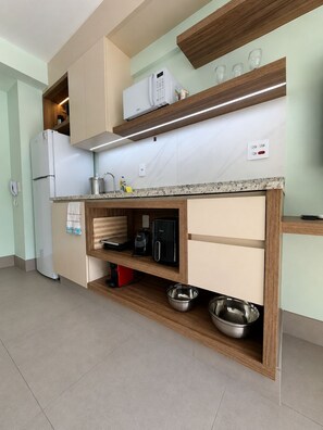 A modern kitchen with built-in appliances, a countertop with a coffee maker, and a microwave. - SETIN 806 (São Paulo)