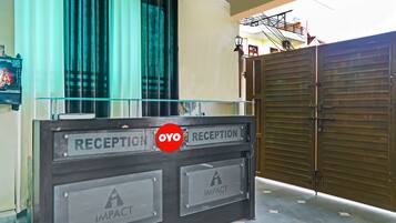 Un mostrador de recepción con un cartel que dice 'RECEPTION' y 'OYO RECEPTION'.