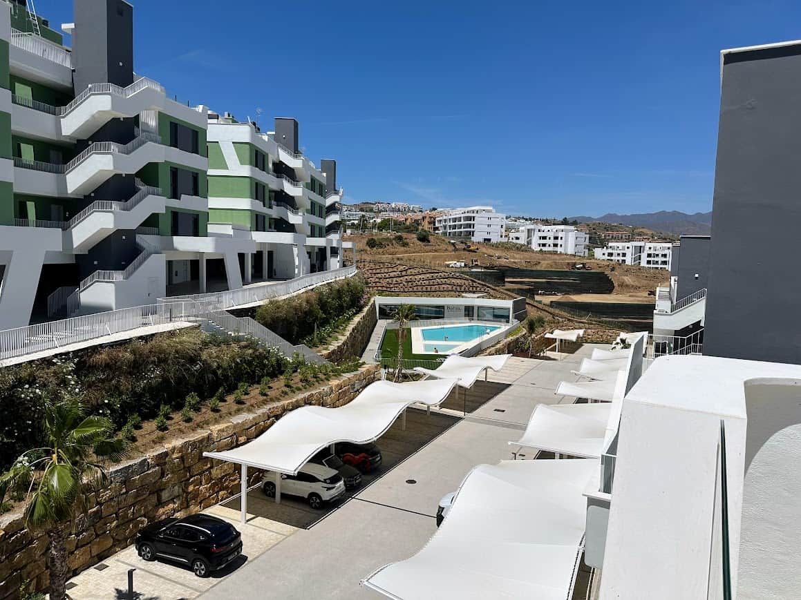 Un bâtiment moderne doté de nombreux balcons, d’une piscine et d’espaces de détente en plein air.