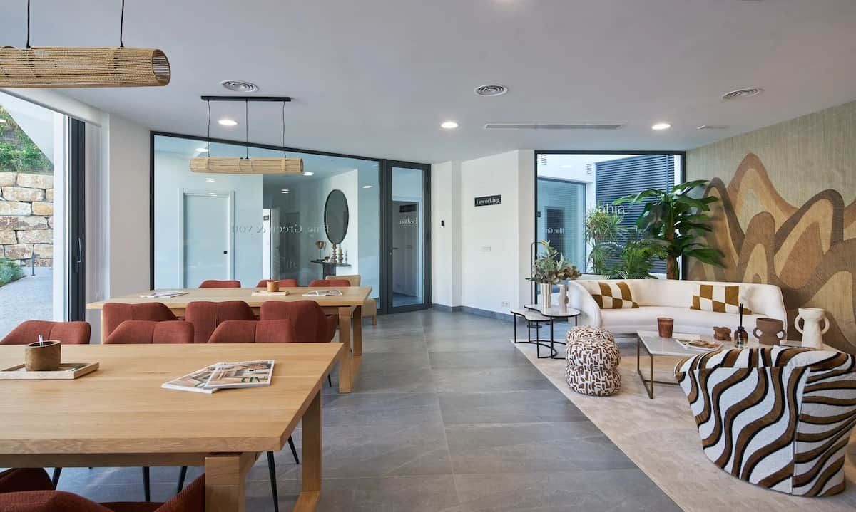 A modern hotel lobby with a dining area, seating, and a large window.