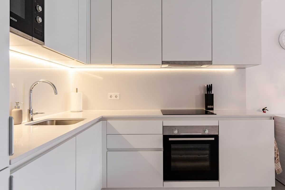 A modern kitchen with a built-in oven, a sink, and a Bosch microwave.
