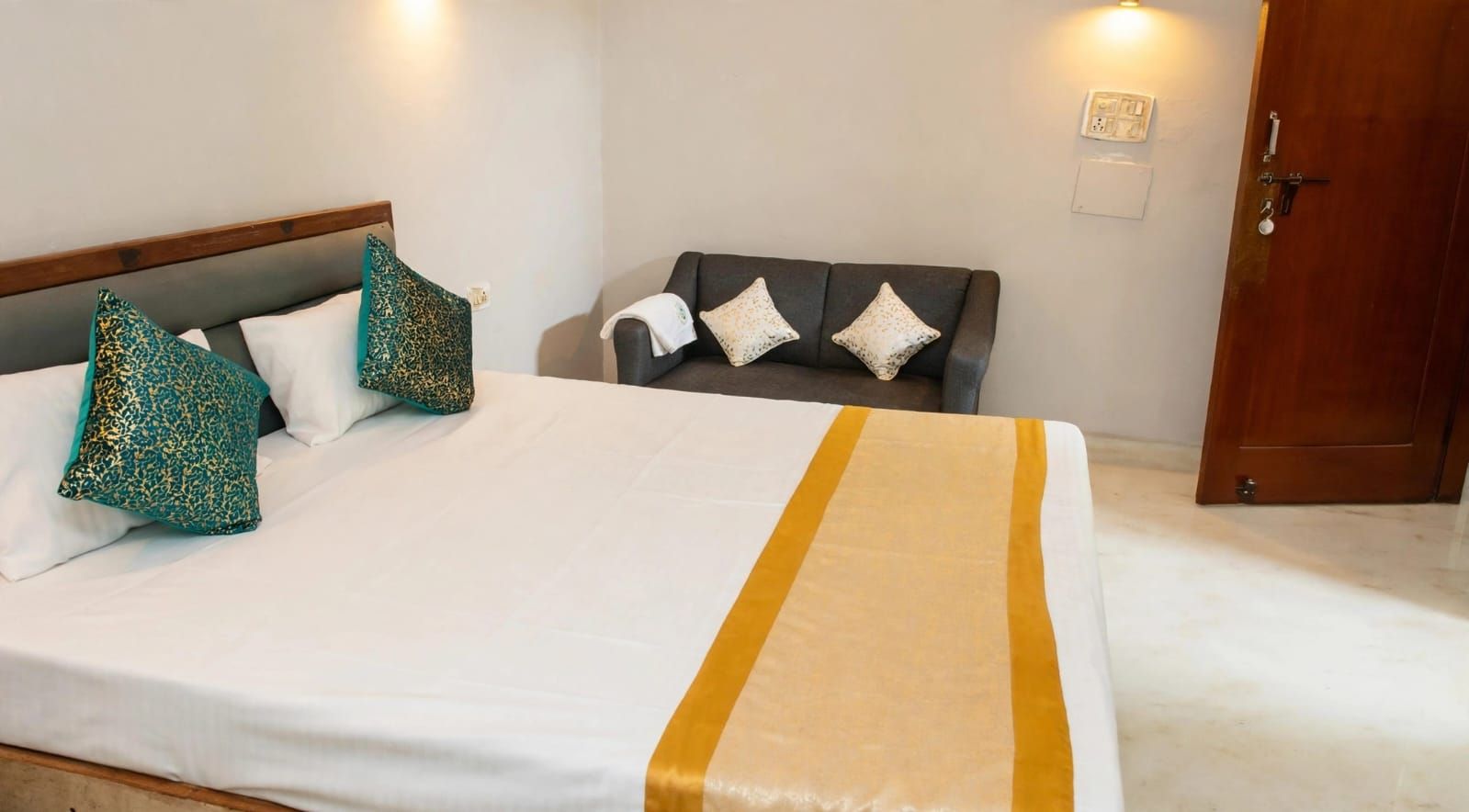 Una habitación de hotel con cama, sofá y puerta.