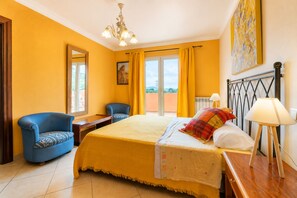 A hotel room with a bed, two armchairs, a desk, a lamp, and a painting on the wall. - Vistabona, 5StarsHome Mallorca Villa (Capdepera)