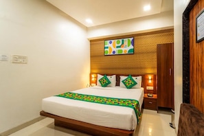 A hotel room with a bed, bedside tables, a wardrobe, and a decorative wall panel. - Treebo Ten Eleven Grand, Scheme 78 (Indore)
