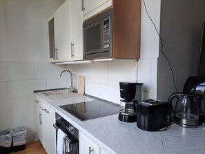 Una cocina equipada con microondas, cafetera y tostadora.