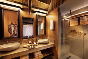 Un baño con dos lavamanos grandes, un espejo, una ducha y un perchero para toallas.