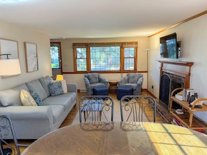 A living room with a sofa, two patterned armchairs, a coffee table, and a fireplace. - Relax and enjoy all that the Cape has to offer in this 3 bedroom home. (Dennis Port)