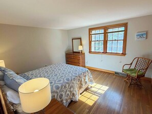 A bedroom with a bed, dresser, chair, and a window. - Relax and enjoy all that the Cape has to offer in this 3 bedroom home. (Dennis Port)