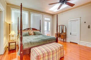 A bedroom with a four-poster bed, a nightstand, a dresser, a mirror, and a ceiling fan. - Classic Meridian Home Near Downtown Attractions (Meridian)
