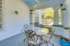 A covered patio with a glass table and metal chairs, a ceiling fan, and a view of trees. - Classic Meridian Home Near Downtown Attractions (Meridian)