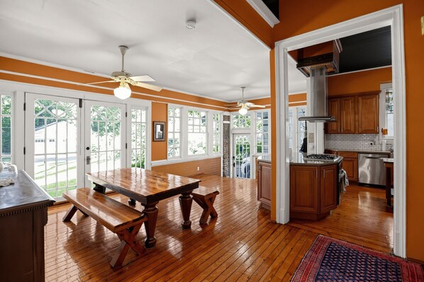 A spacious kitchen with wooden cabinets, a large island, and a view of the outdoors.