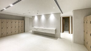 A modern bathroom with lockers, a marble vanity, and a shower area. - Majestic Hajar Mountain Views 1BR and Beach Access, Near Khorfakkan Amphitheatre (Khor Fakkan)