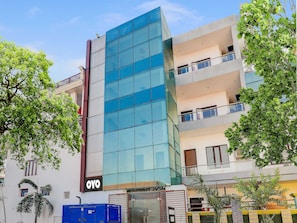 A multi-story building with a glass facade, a visible 'OYO' sign, and balconies on the upper floors. - Collection O Kiara Guest House (Lucknow)
