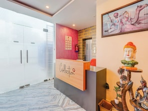 A reception desk with a 'Collection' sign, a fire extinguisher, a framed painting, and a Buddha statue. - Collection O Kiara Guest House (Lucknow)