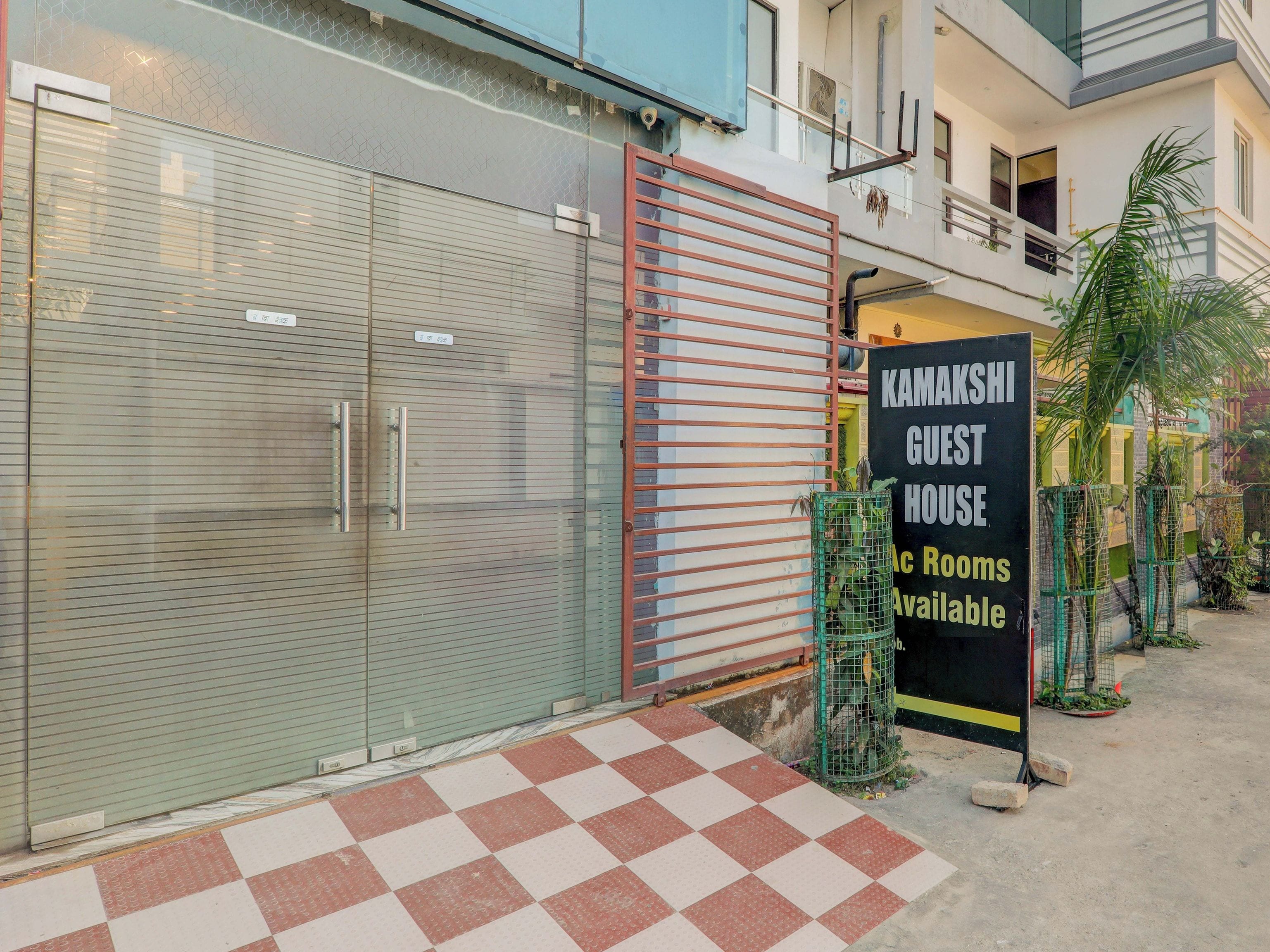 Una entrada cerrada con un cartel que dice 'KAMAKSHI GUEST HOUSE' y un diseño de piso a cuadros.