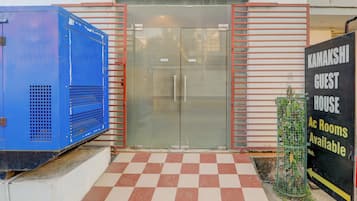 A gated entrance with a checkered floor, a blue storage unit, and a sign indicating guest rooms are available.
