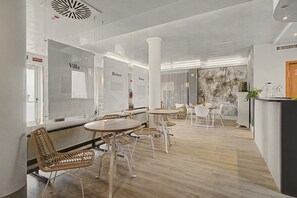 Ein modernes Interieur mit Barbereich, Sitzgelegenheiten mit Korbstühlen und einer Wanddekoration mit einer Pflanzenausstellung.