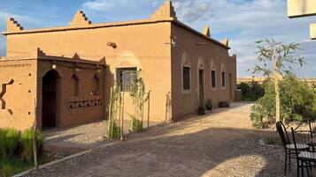 A building with a traditional architectural style, a gravel pathway, and a small seating area.