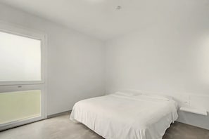 A minimalistic bedroom with a single bed, a window, and a white wall. - Room 'Camera Matrimoniale Standard' with Wi-Fi and Air Conditioning (Dolo)