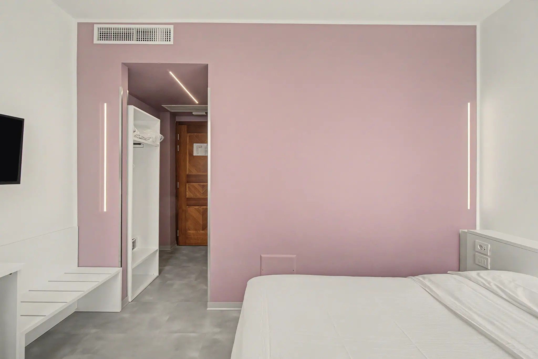 Une chambre à coucher avec un lit, une armoire et un miroir.
