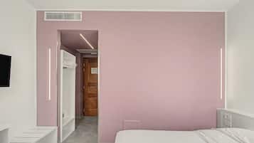 A bedroom with a bed, a wardrobe, and a mirror.