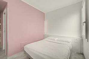 A bedroom with a bed, a door, and a wall with a switch. - Room 'Camera Matrimoniale Standard' with Wi-Fi and Air Conditioning (Dolo)