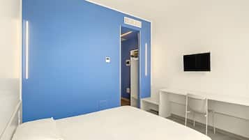 A hotel room with a large bed, a wardrobe, a desk, and a TV.