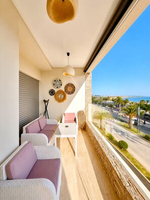 A balcony with wicker furniture, a ceiling light, and decorative plates. - Vrbo Property (Agadir)