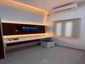 A modern bathroom with a built-in TV, a small stool, and a window. - Cozzy Wisma Embun Raya A3G (PALANGKA RAYA)