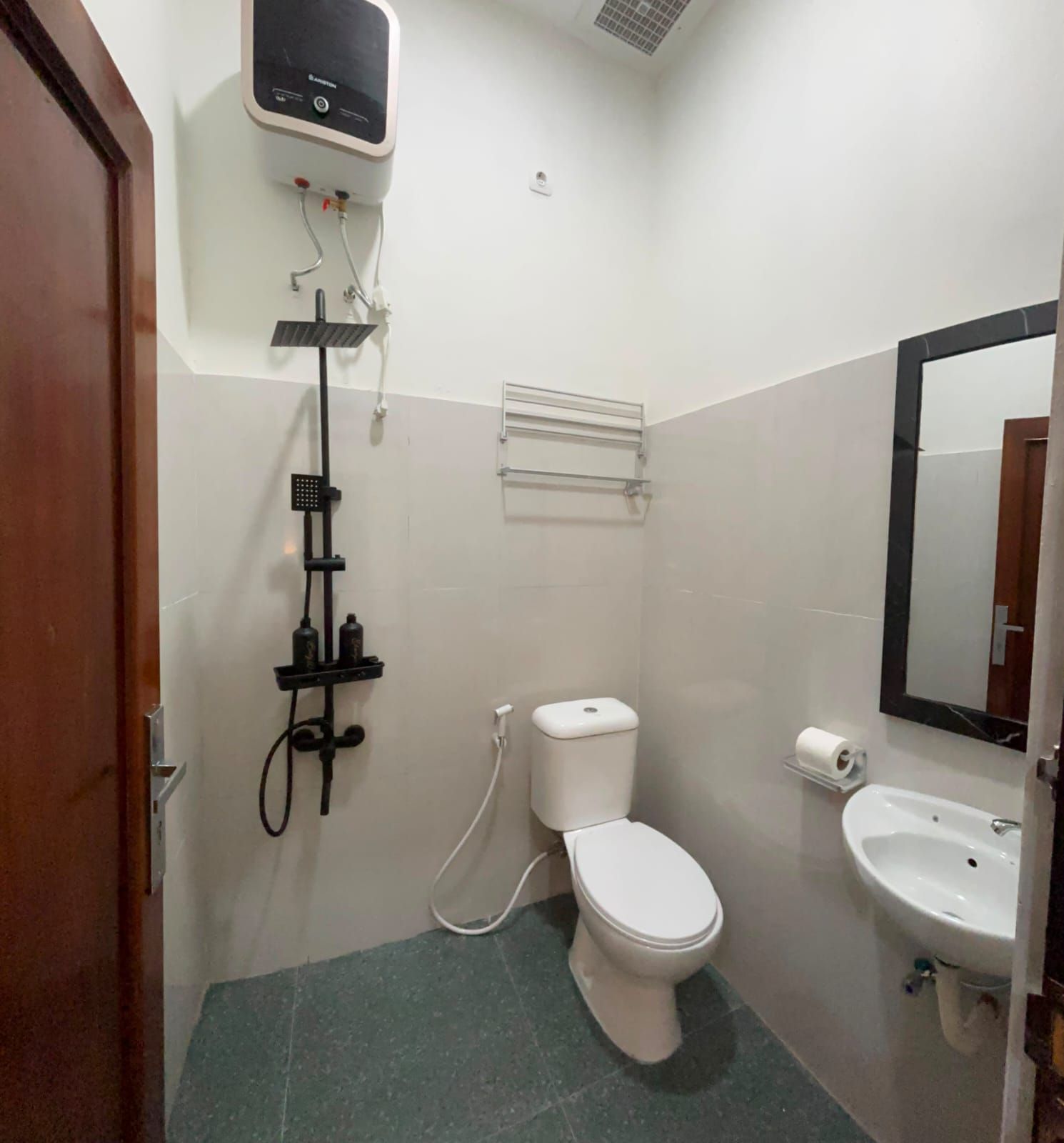 A bathroom with a toilet, sink, and shower unit.