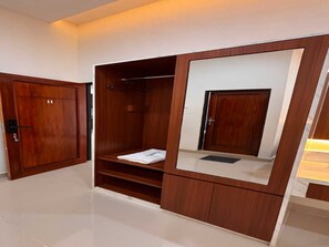 A wooden wardrobe with a mirror, a shelf, and a hanging space.