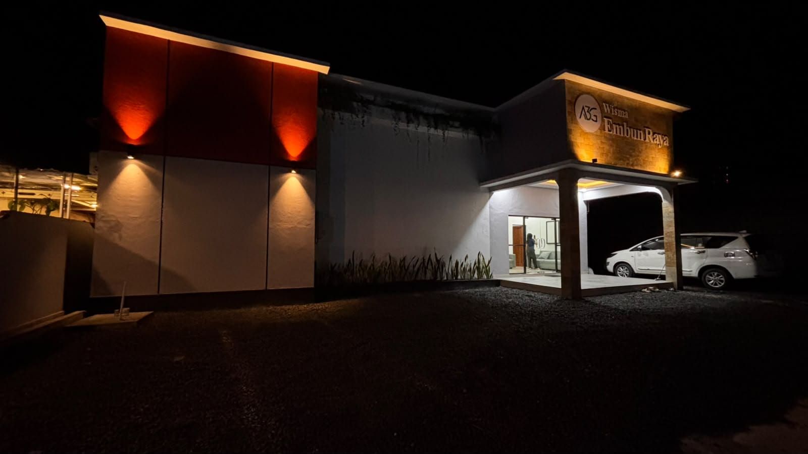 A building with a sign reading 'A35 Wisma Embun Raya' at night.
