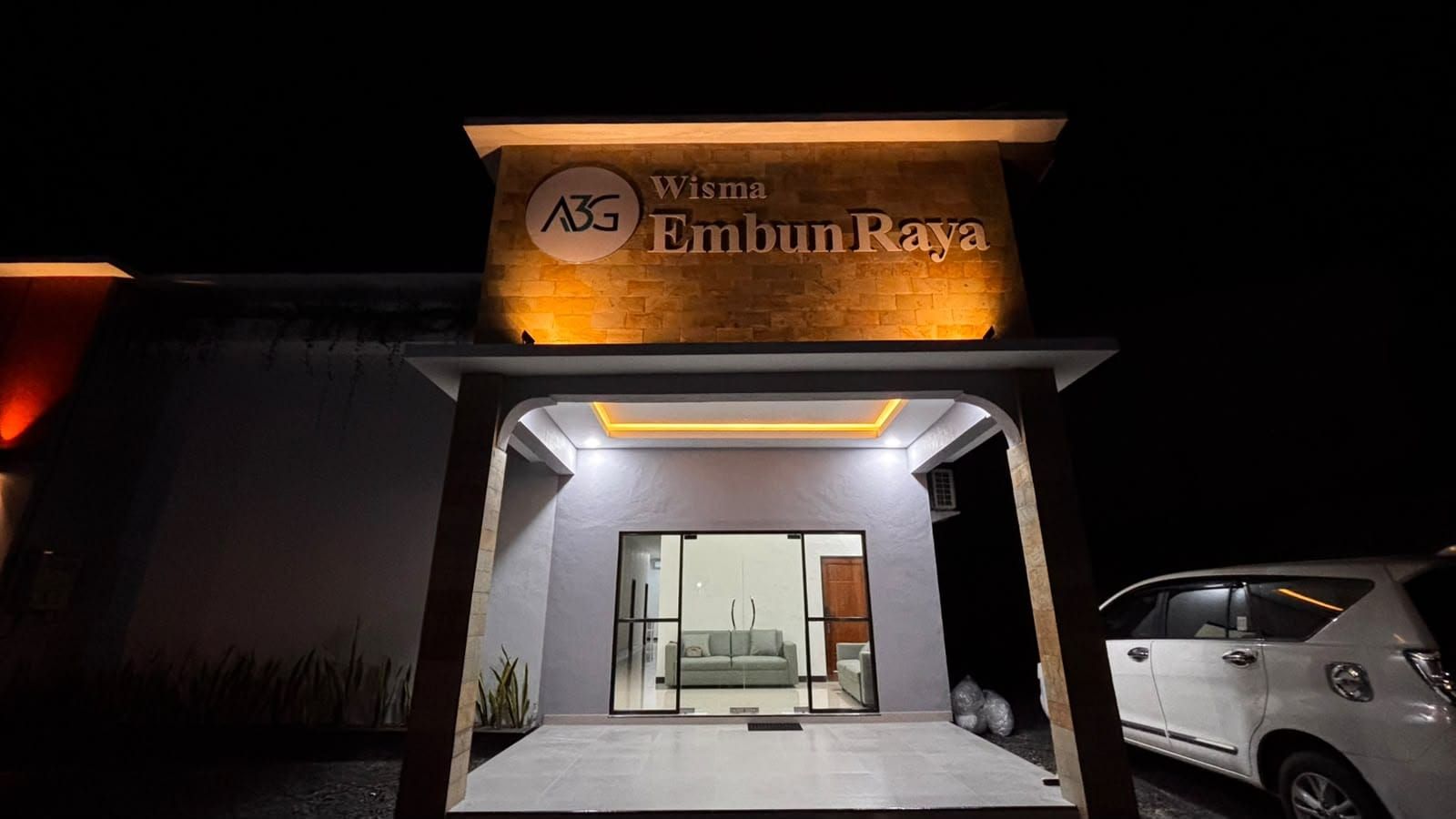 Un edificio moderno con un letrero que dice 'Wisma Embun Raya' y un logotipo 'ABG'.