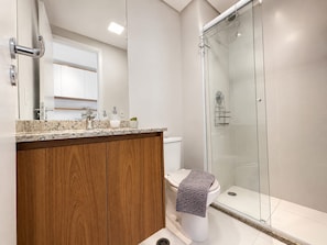 A modern bathroom with a wooden vanity, a glass shower enclosure, and a white toilet. - SETIN 1504 (São Paulo)
