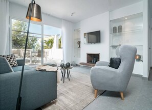 A modern living room with a sofa, armchair, and a fireplace. - AB3 - Spacious holiday home, Puerto Banus (Marbella)