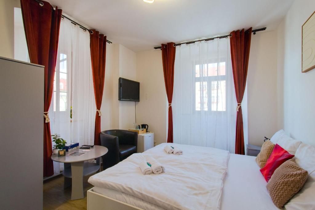 Una camera d'albergo con un letto, una scrivania, una sedia e una televisione.