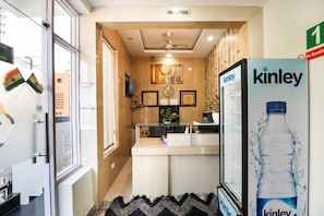 A reception area with a reception desk, a clock, and a wall-mounted sign indicating the reception. - Hotel O Kiara Inn (Lucknow)