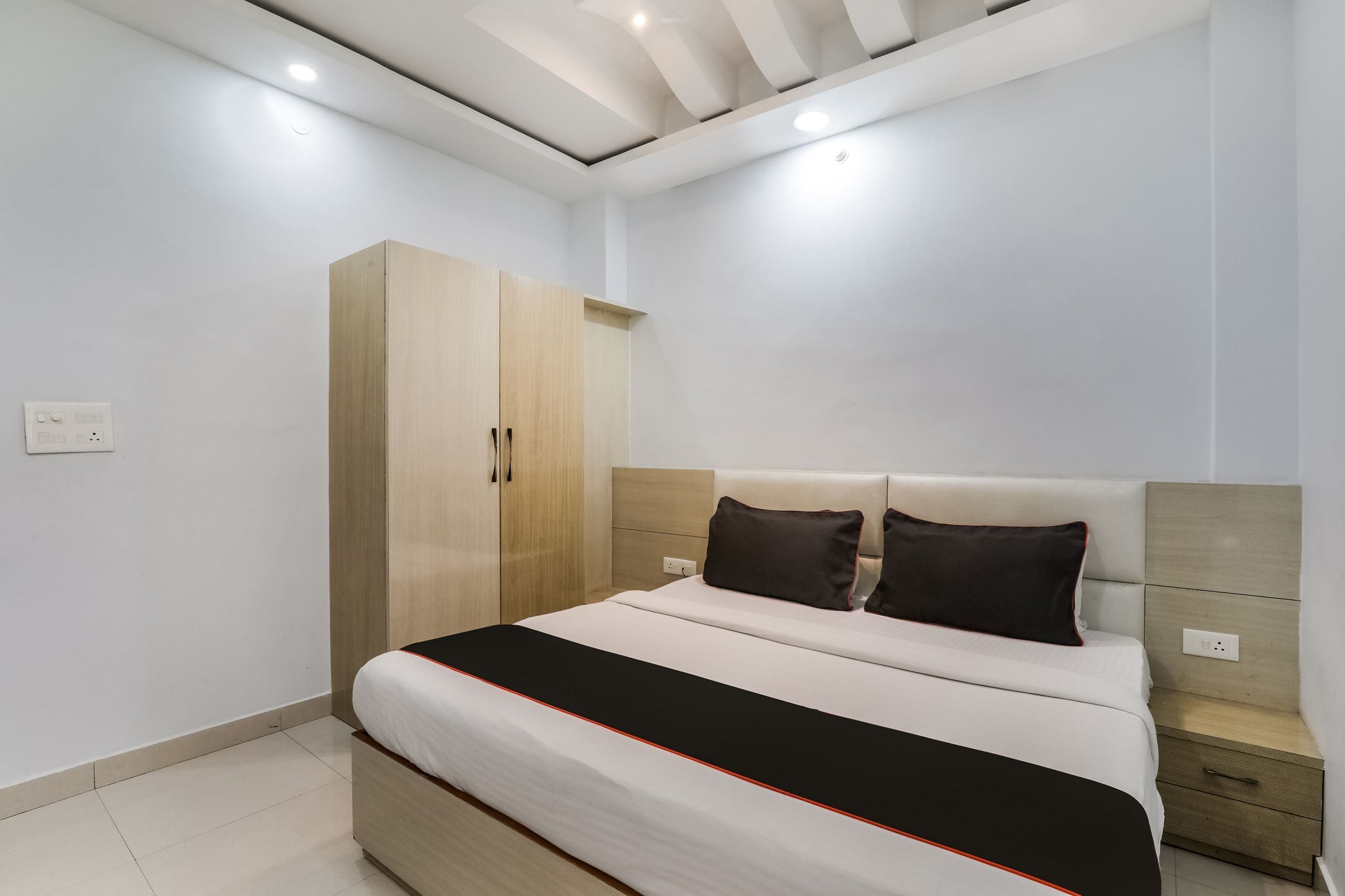 Un dormitorio con una cama, un armario y una mesita de noche.