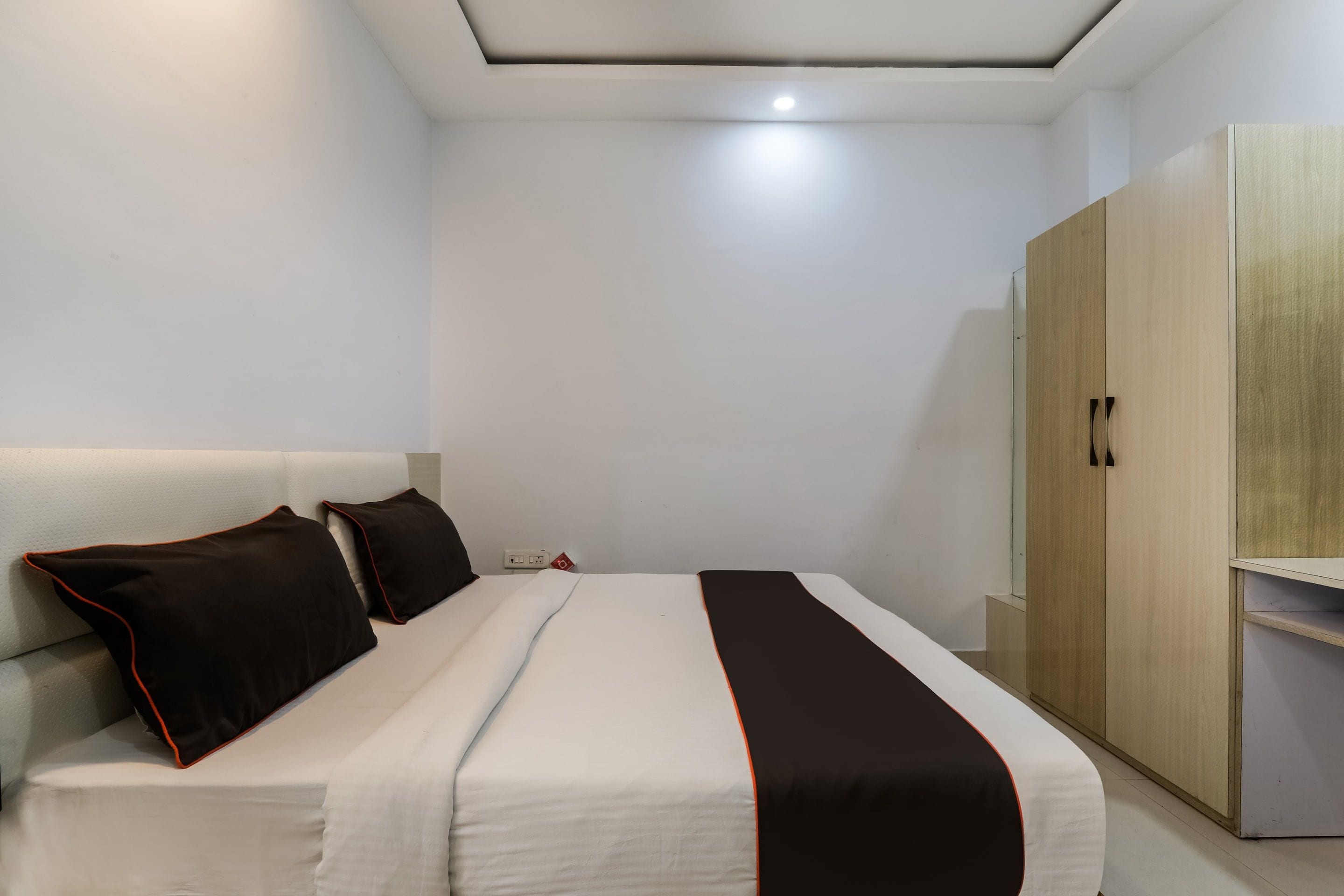 Ein Schlafzimmer mit Bett, Kleiderschrank und Deckenleuchte.