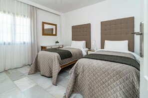 A hotel room with two beds, a bedside table, a mirror, and a window with curtains. - AB4 - Lovely holiday home walking distance, beach (Marbella)