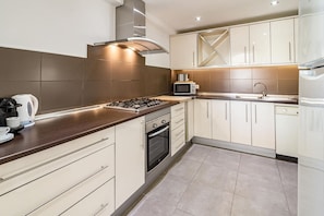 A modern kitchen with a gas stove, oven, microwave, and stainless steel sink. - AB4 - Lovely holiday home walking distance, beach (Marbella)