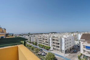 Ein Wohngebiet mit modernen Gebäuden, blauem Himmel und Blick aufs Meer.