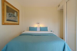 A hotel room with a bed, a painting on the wall, and a window with blinds. - Penthouse Walk to Beach & Town - ADB352 (Marbella)